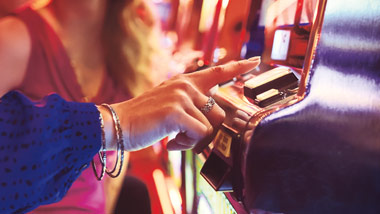 pushing a button on a slot machine in a casino