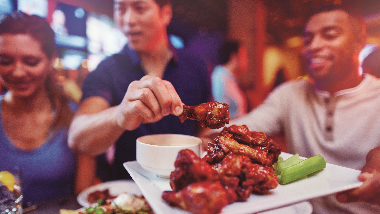 Guy holding a plate of wings